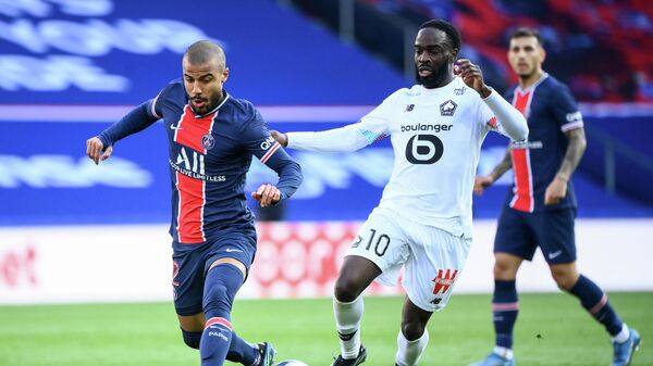 Paris Saint-Germain's Brazilian midfielder Rafinha (L) fights for the ball with Lille's French midfielder Jonathan Ikone during the French L1 football match between Paris-Saint Germain (PSG) and Lille (LOSC) at the Parc des Princes Stadium in Paris, on April 3, 2021. (Photo by FRANCK FIFE / AFP)