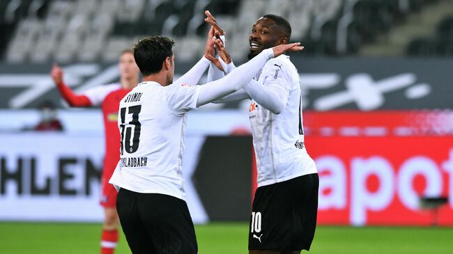 Moenchengladbach's French forward Marcus Thuram celebrates after scoring together with his teammates Moenchengladbach's German forward Lars Stindl (L) during the German first division Bundesliga football match between Borussia Moenchengladbach and SC Freiburg in Moenchengladbach, western Germany, on April 3, 2021. (Photo by UWE KRAFT / AFP) / DFL REGULATIONS PROHIBIT ANY USE OF PHOTOGRAPHS AS IMAGE SEQUENCES AND/OR QUASI-VIDEO