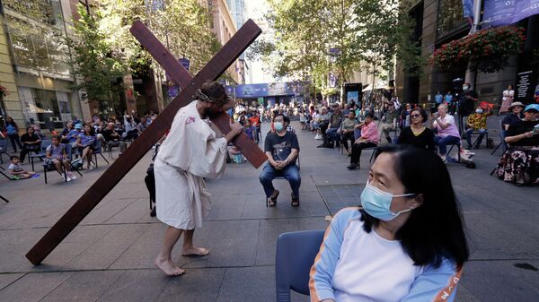 Актер несет крест, изображения Иисуса Христа во время празднования Страстной пятницы в Сиднее