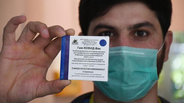 Медицинский работник держит в руках упаковку с российским препаратом от коронавирусной инфекции Гам-Ковид-Вак (Спутник V)