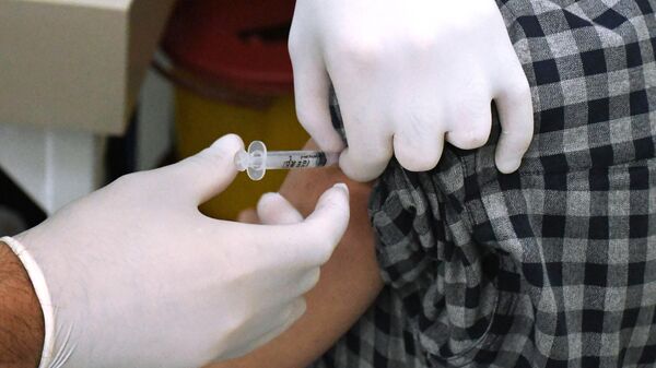 Девушка во время вакцинации от коронавирусной инфекции российским препаратом Гам-Ковид-Вак (Спутник V) в Карачи
