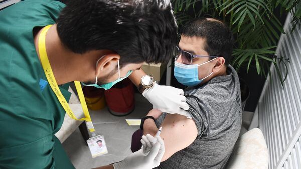 Мужчина во время вакцинации от коронавирусной инфекции российским препаратом Гам-Ковид-Вак (Спутник V) в Карачи