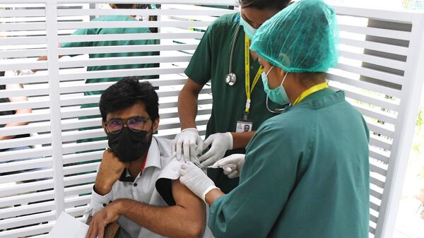 Молодой человек во время вакцинации от коронавирусной инфекции российским препаратом Гам-Ковид-Вак (Спутник V) в Карачи