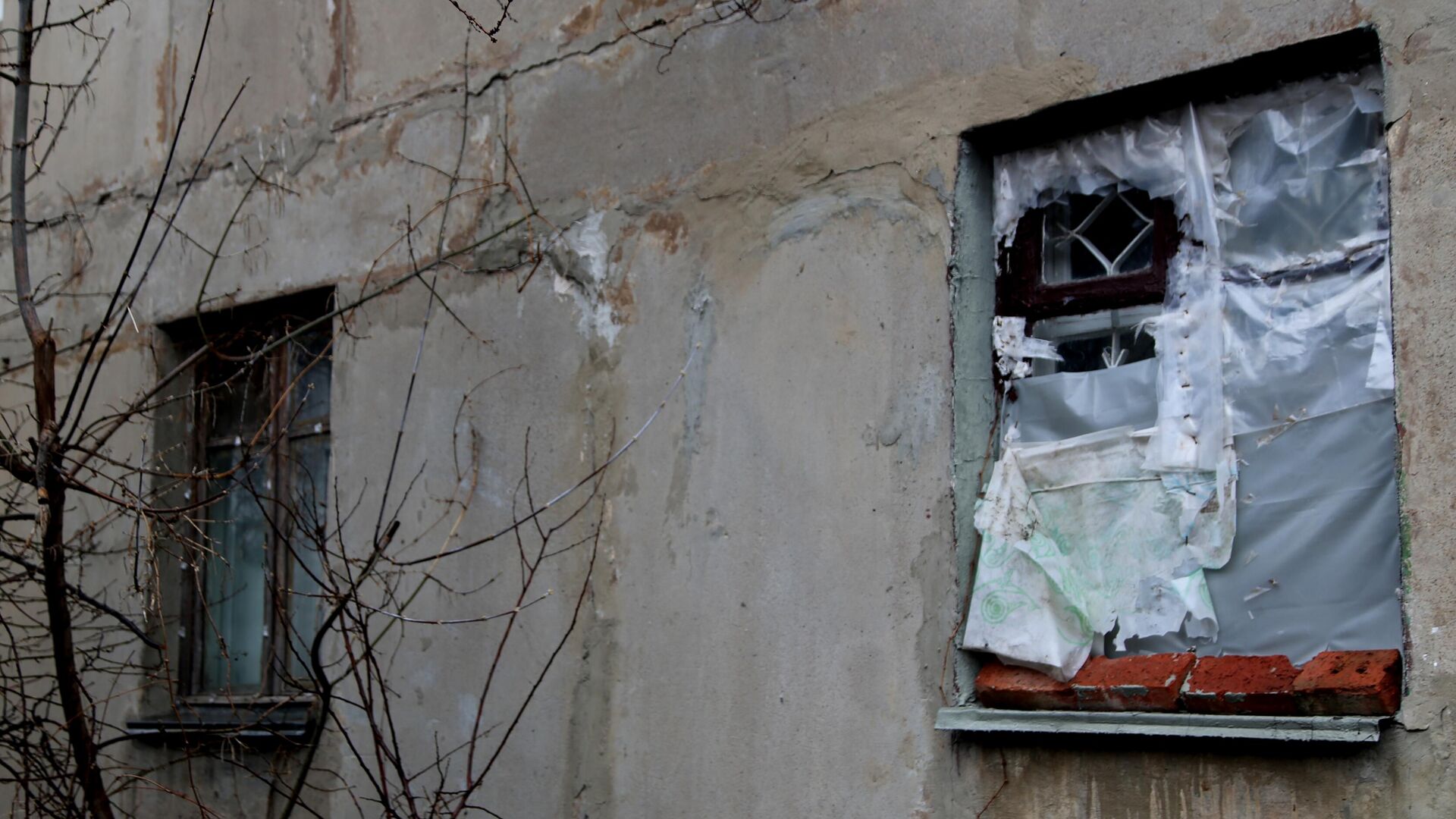 Окно без стекол, затянутое полиэтиленовой пленкой, в одном из домов поселка шахты Глубокая в Горловке - РИА Новости, 1920, 05.04.2021