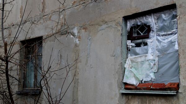 Окно без стекол, затянутое полиэтиленовой пленкой, в одном из домов поселка шахты Глубокая в Горловке
