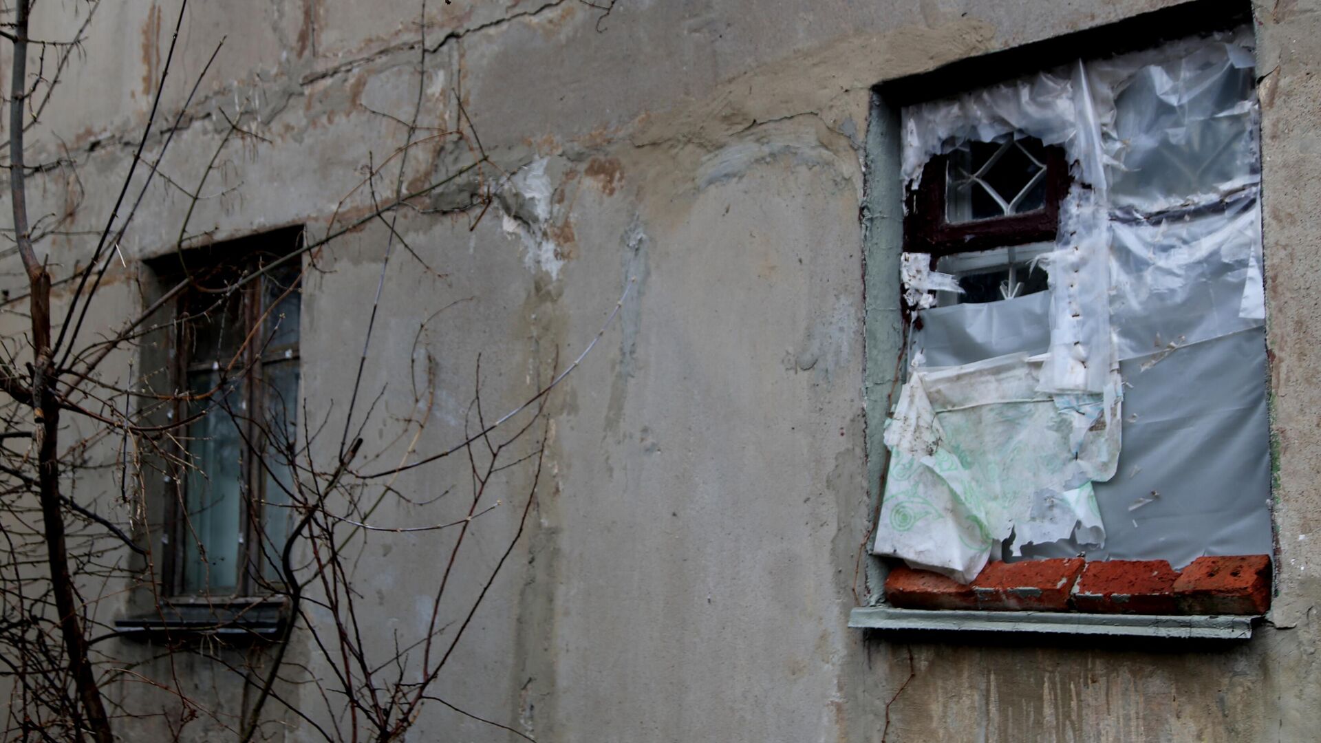 Окно без стекол, затянутое полиэтиленовой пленкой, в одном из домов поселка шахты Глубокая в Горловке - РИА Новости, 1920, 05.06.2021