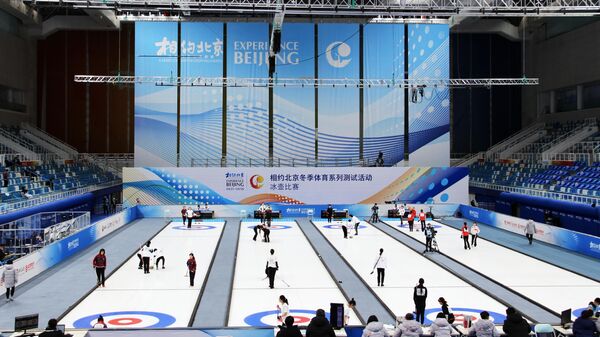 Участники соревнования по кёрлингу во время тестовых соревнований зимних Олимпийских игр 2022 в Национальном плавательном центре Ледяной куб (Ice Сube) в Пекине.