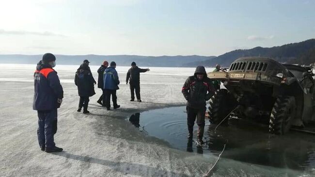 Сотрудники МЧС РФ вытаскивают из воды грузовой автомобиль, который провалился под лед на озере Байкал