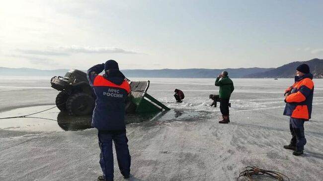 Сотрудники МЧС РФ вытаскивают из воды грузовой автомобиль, который провалился под лед на озере Байкал