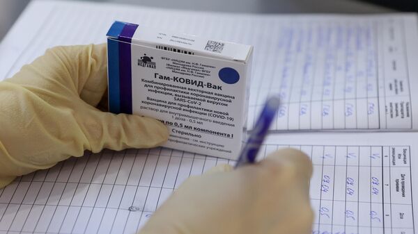 Медицинская сестра держит в руке упаковку с вакциной Гам-КОВИД-Вак (Спутник V) 