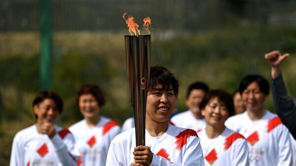 Японский факелоносец Азуса Ивашимицу во время эстафеты Олимпийского огня в Токио