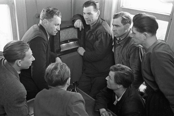 Рабочие совхоза Заокский слушают сообщение по радиоприемнику о полете космического корабля Восток-1 с  космонавтом Юрием Алексеевичем Гагариным на борту