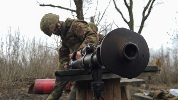 Военнослужащий украинских вооруженных сил чистит оружие на боевых позициях на линии разделения возле  города Донецк