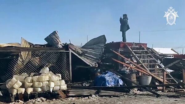 Сотрудник МЧС осматривает последствия пожара в жилом доме в Якутии