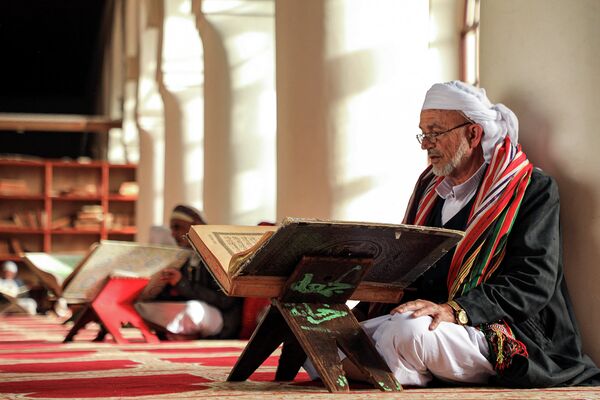 Мужчина читает Коран в Большой мечети Саны, Йемен
