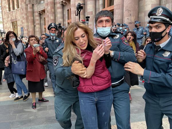 Сотрудники полиции задерживают участницу акции протеста с требованием отставки премьер-министра Никола Пашиняна у здания правительства Армении в Ереване