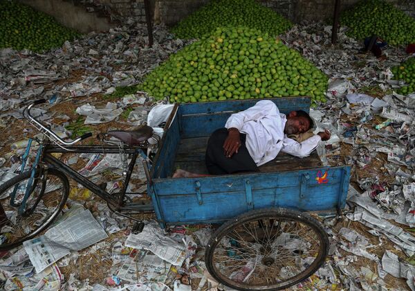 Рикша отдыхает на фруктовом рынке в Хайдарабаде в Индии