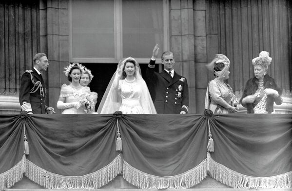 Королева Великобритании Елизавета II и ее супруг герцог Эдинбургский машут толпе с балкона Букингемского дворца