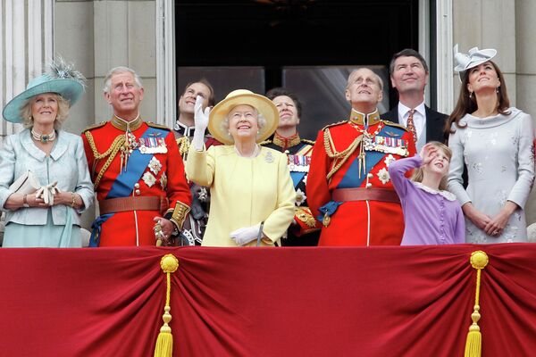Королева Великобритании Елизавета II и ее семья смотрят за пролетом самолета Королевских ВВС с балкона Букингемского дворца