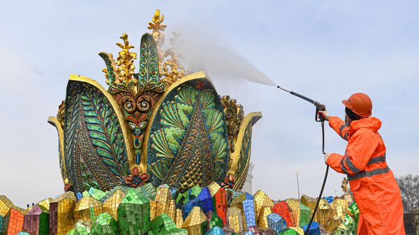 Работник моет скульптурную композицию фонтана Каменный цветок на ВДНХ в Москве