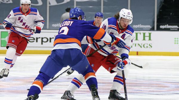 UNIONDALE, NEW YORK - APRIL 09: Artemi Panarin #10 of the New York Rangers carries the puck in on Nick Leddy #2 of the New York Islanders at Nassau Coliseum on April 09, 2021 in Uniondale, New York.   Bruce Bennett/Getty Images/AFP (Photo by BRUCE BENNETT / GETTY IMAGES NORTH AMERICA / Getty Images via AFP)