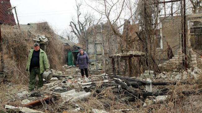 Жители возле разрушенного дома в Донецкой области