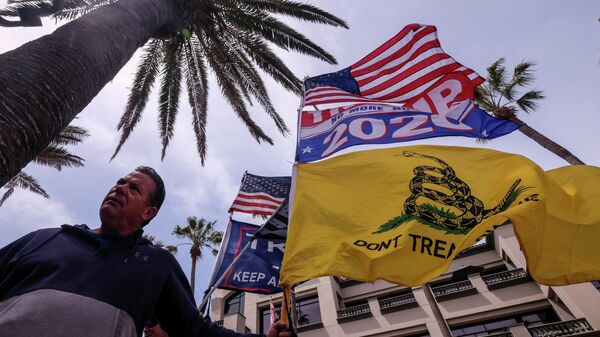 Мужчина с флагами на акции White Lives Matter в Хантингтон-Бич, Калифорния, США