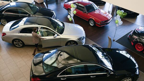 Менеджер демонстрирует покупателям автомобиль в автосалоне