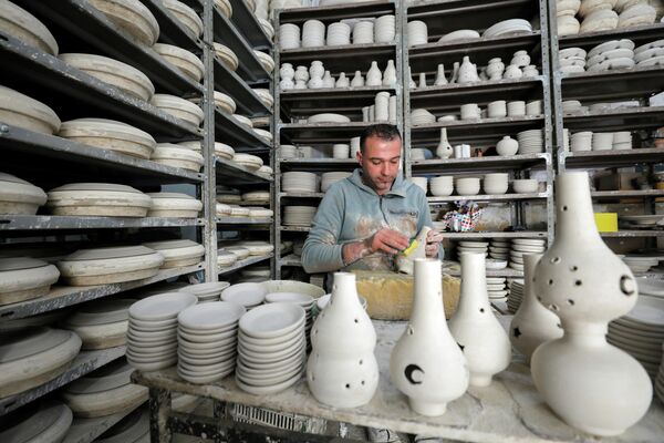 Палестинец изготавливает керамические горшки для продажи в преддверии священного месяца Рамадан в Хевроне в южной части Западного берега реки Иордан