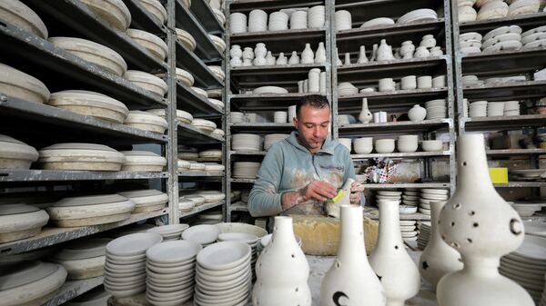 Палестинец изготавливает керамические горшки для продажи в преддверии священного месяца Рамадан в Хевроне в южной части Западного берега реки Иордан