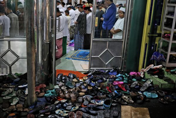 Обувь оставленная снаружи в мечети в Джакарте, Индонезия. 12 апреля 2021 года