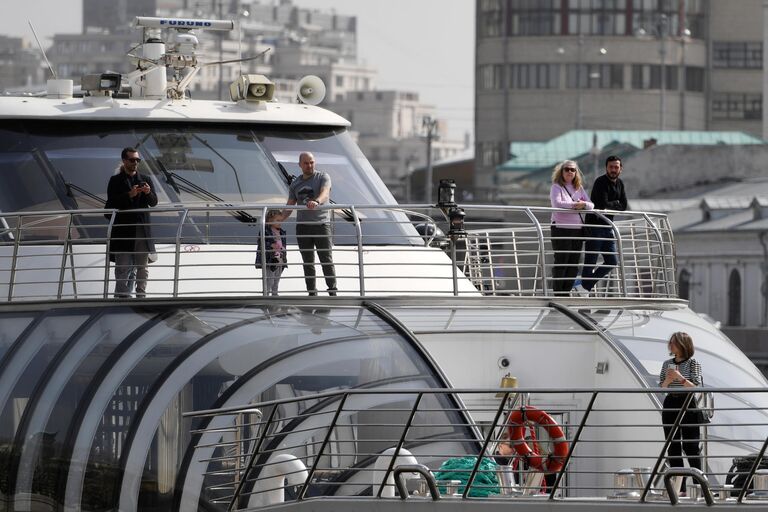 Пассажиры на борту теплохода у причала Устьинский мост перед речной прогулкой по Москве-реке