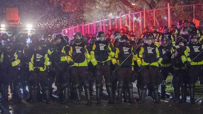 Сотрудники полиции во время акции протеста в городе Бруклин-Сентер в штате Миннесота
