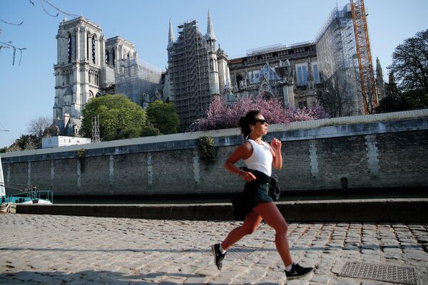 Женщина на пробежке перед собором Парижской Богоматери