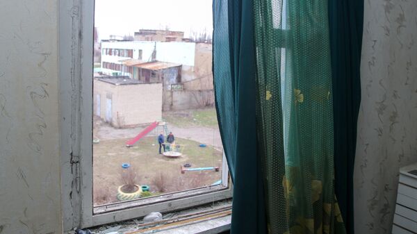 Разбитое окно в жилом доме в Киевском районе Донецка, пострадавшем в результате обстрела