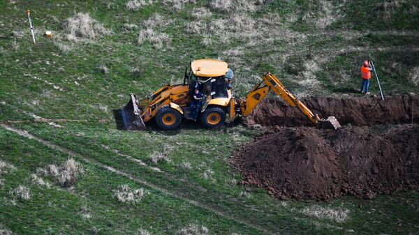 Трактор копает траншею в Московской области