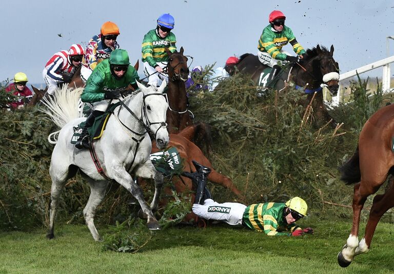 Участники скачек во время ежегодного фестиваля Grand National на ипподроме Эйнтри, Великобритания