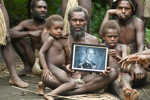 Глава деревни Якель Альби и члены его семьи держат портрет британского принца Филиппа, герцога Эдинбургского, в отдаленной тихоокеанской деревне Вануату
