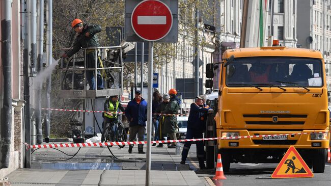 Сотрудники коммунальной службы во время промывки фасадов в Москве