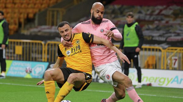 Wolverhampton Wanderers' Moroccan midfielder Romain Saiss (L) vies with Sheffield United's English-born Irish striker David McGoldrick (R) during the English Premier League football match between Wolverhampton Wanderers and Sheffield United at the Molineux stadium in Wolverhampton, central England on April 17, 2021. (Photo by Geoff Caddick / POOL / AFP) / RESTRICTED TO EDITORIAL USE. No use with unauthorized audio, video, data, fixture lists, club/league logos or 'live' services. Online in-match use limited to 120 images. An additional 40 images may be used in extra time. No video emulation. Social media in-match use limited to 120 images. An additional 40 images may be used in extra time. No use in betting publications, games or single club/league/player publications. / 
