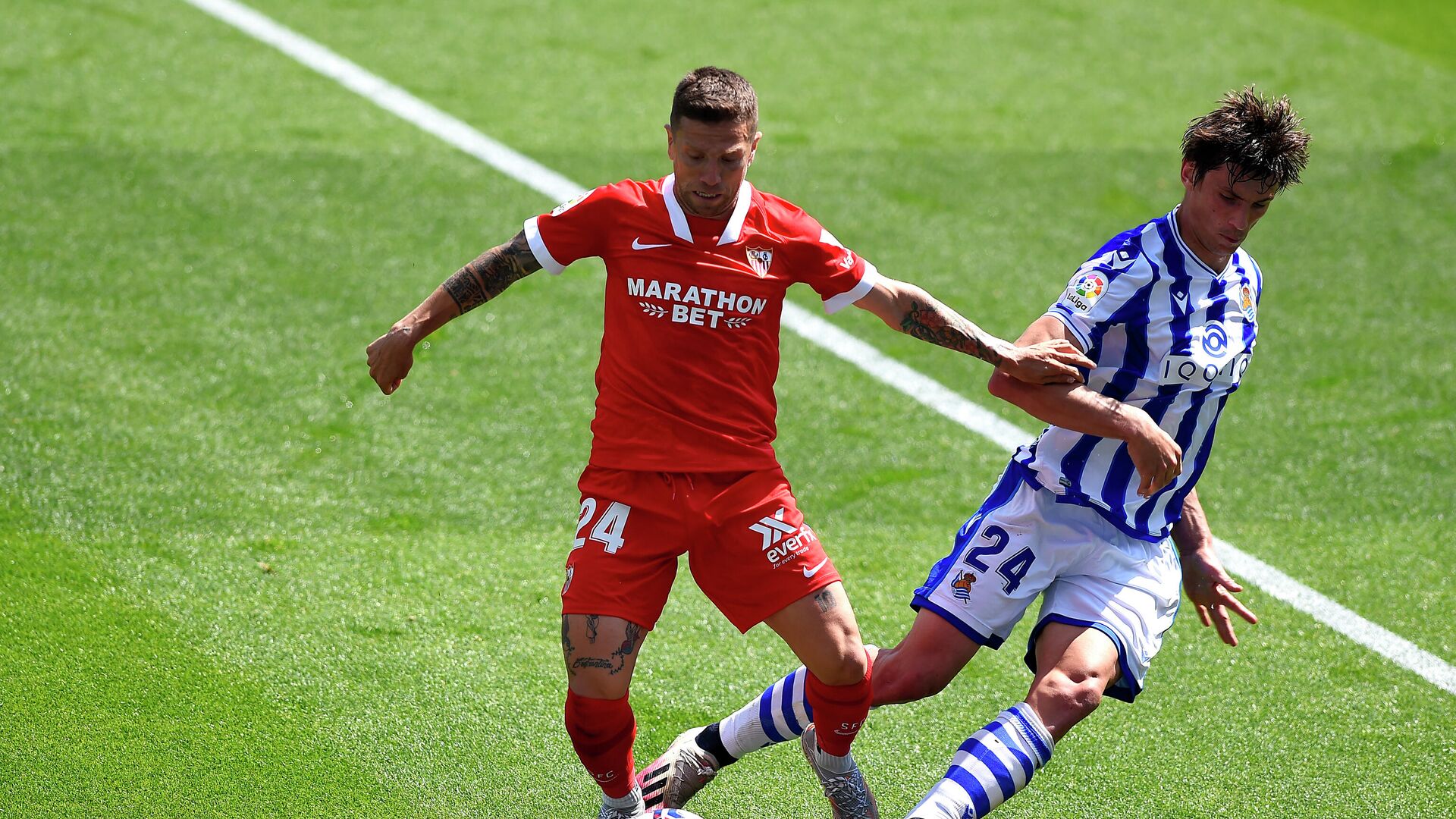 Sevilla's Argentinian forward Papu Gomez (L) challenges Real Sociedad's French defender Robin Le Normand during the Spanish League football match between Real Sociedad and Sevilla FC at the Anoeta stadium in San Sebastian on April 18, 2021. (Photo by ANDER GILLENEA / AFP) - РИА Новости, 1920, 18.04.2021