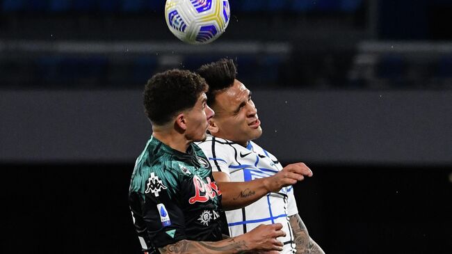 Napoli's Italian defender Giovanni Di Lorenzo (L) and Inter Milan's Argentine forward Lautaro Martinez go for a header during the Italian Serie A football match Napoli vs Inter on April 18, 2021 at the Diego Maradona (San Paolo) stadium in Naples. (Photo by Tiziana FABI / AFP)