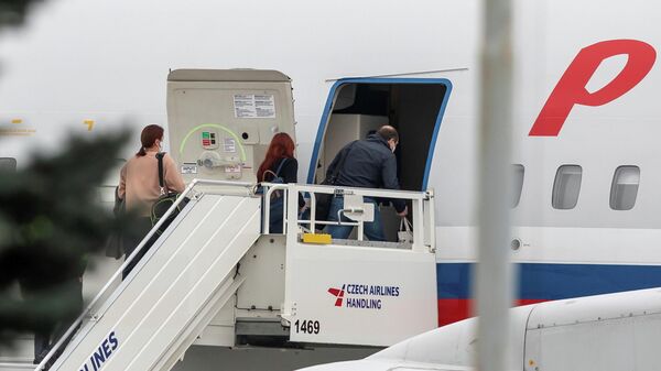 Российские дипломаты заходят в самолет авиакомпании Россия в аэропорту Праги 