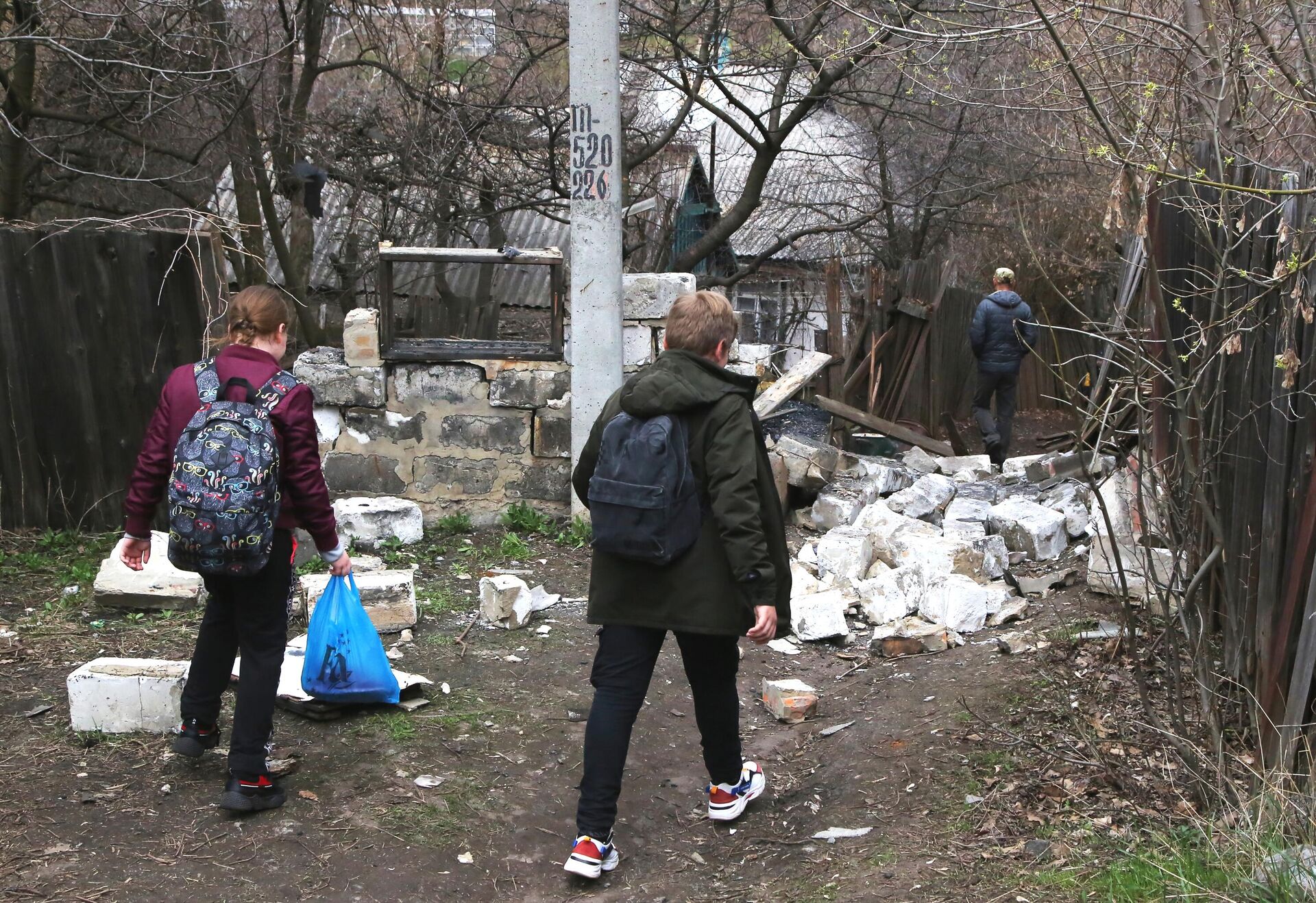 Школьники идут по дороге мимо строения, которое было разрушено в результате утреннего обстрела Горловки - РИА Новости, 1920, 28.07.2021