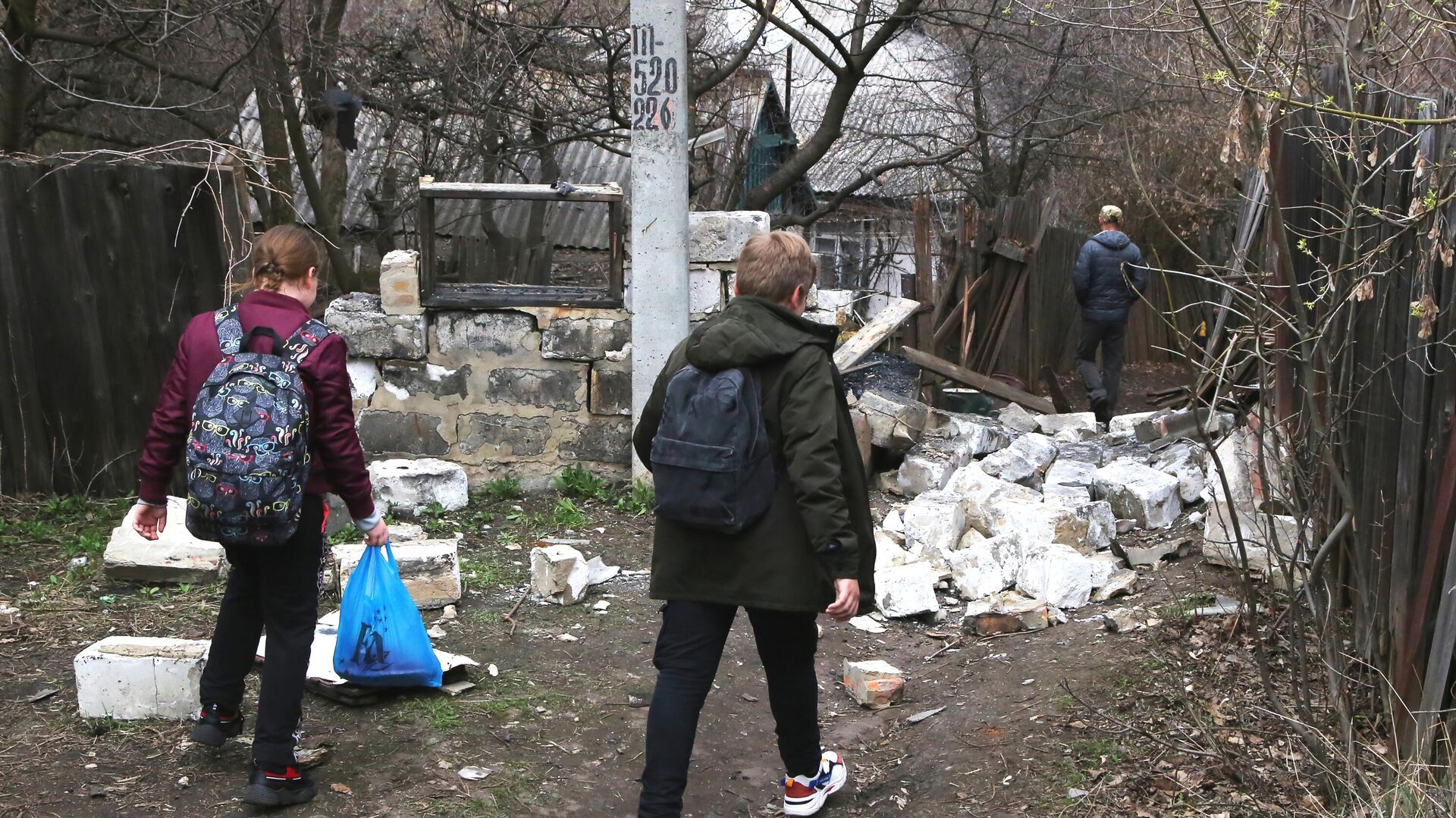 Школьники идут по дороге мимо строения, которое было разрушено в результате утреннего обстрела Горловки - РИА Новости, 1920, 21.04.2021