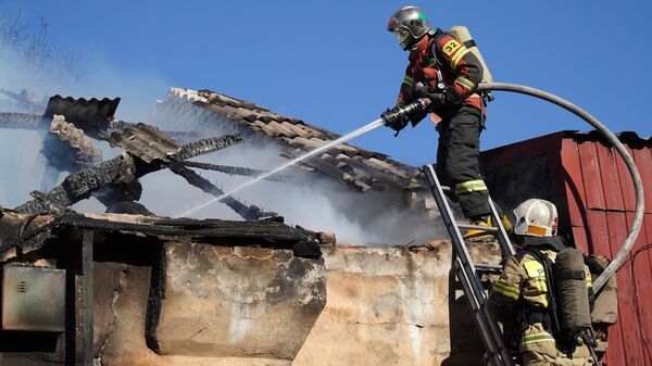 Сотрудники специализированной пожарно-спасательной части ГУ МЧС РФ во время тушения пожара