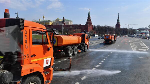 Автомобили коммунальной службы производят мытье асфальтового покрытия в Москве