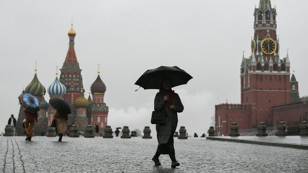 Люди во время дождя на Красной площади в Москве. Архивное фото