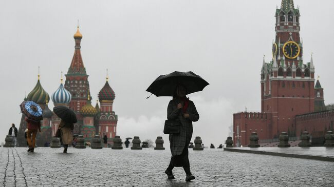 Люди во время дождя на Красной площади в Москве