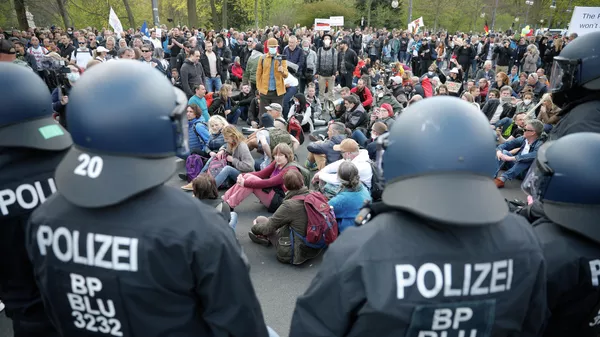 Участники акции протеста против политики правительства Германии по борьбе с пандемией коронавируса и полицейские в Берлине Участники акции протеста против политики правительства Германии по борьбе с пандемией коронавируса и полицейские в Берлине
